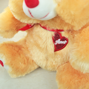 URSO DE PELUCIA DE POLIESTER COM LAÇO 25X22CM - FE6918-CARAMELO